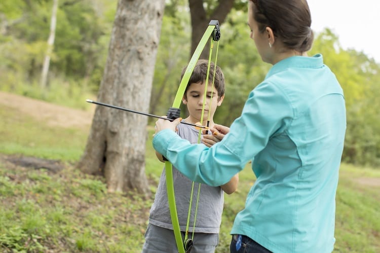 Mom Giving Boy A Bow And Arrow